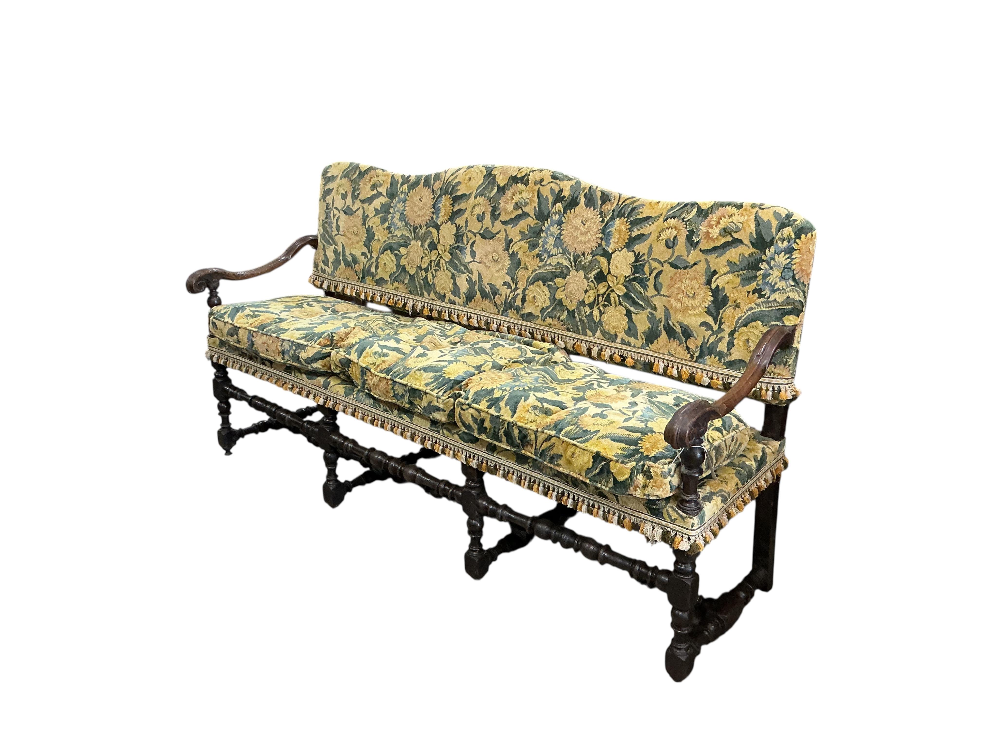 A mid 17th century upholstered walnut settee (provenance, from the Great Hall, Luddesdown Court, Kent), width 196cm, depth 60cm, height 104cm